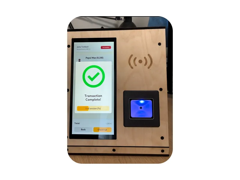 The kiosk's wooden front panel: a touch screen showing a completed transaction, an engraved RFID symbol and a lit barcode scanner.